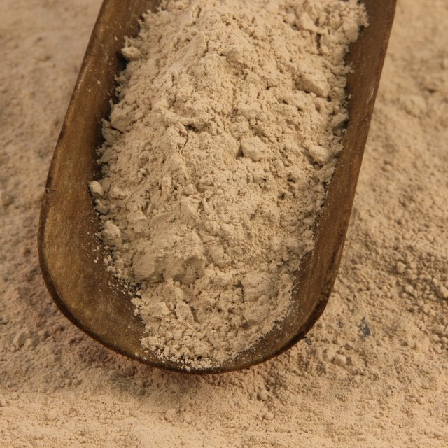 A scoop with azomite rock dust in it.